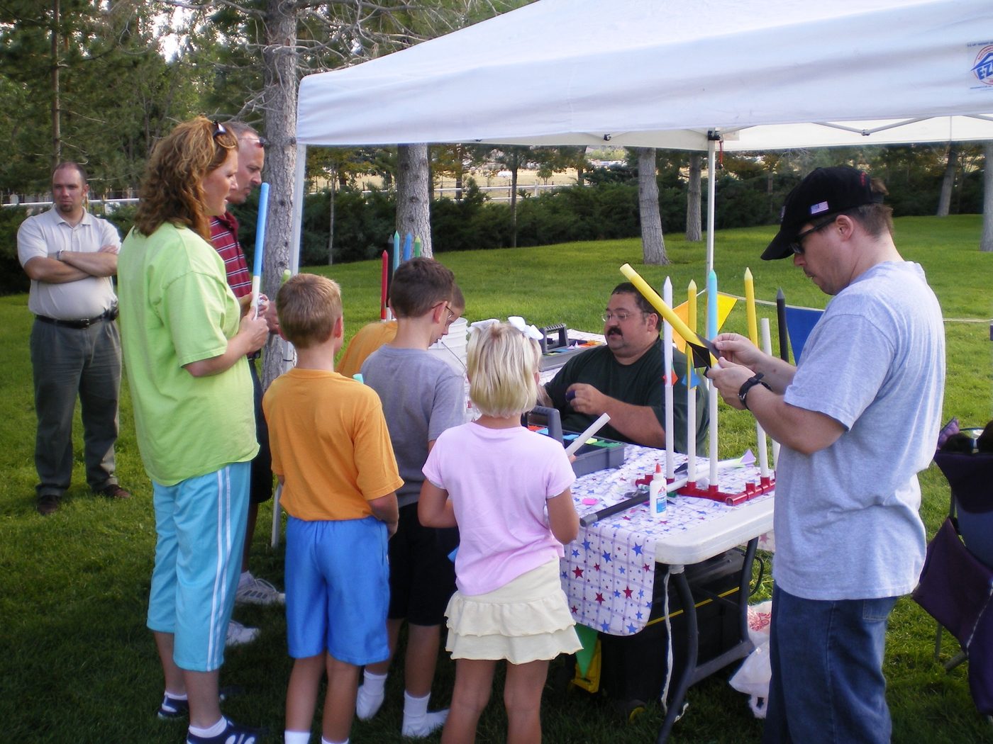 Families building paper rockets at an outdoor It's a Blast event