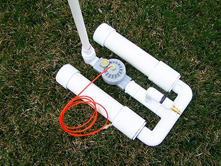 White PVC air-actuated rocket launcher on grass